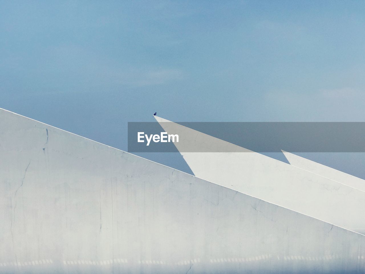 High section of building against blue sky during sunny day