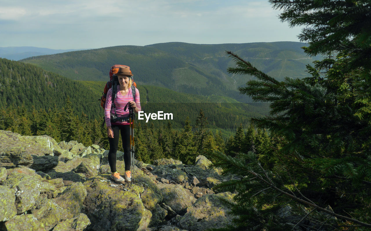 Portrait of smiling young woman standing on mountain