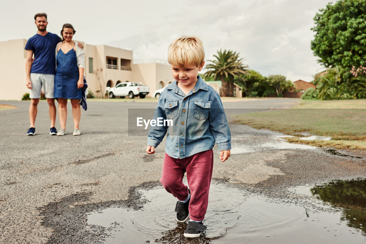 full length of siblings walking on road