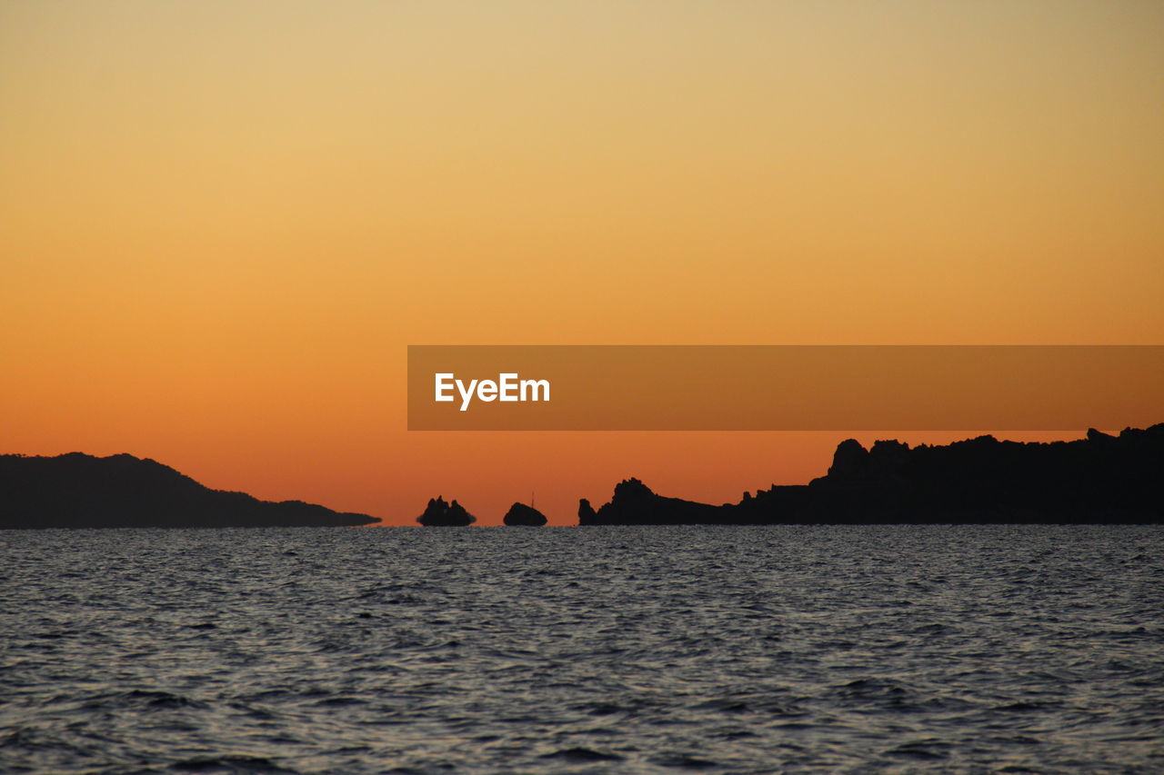 Scenic view of sea against orange sky