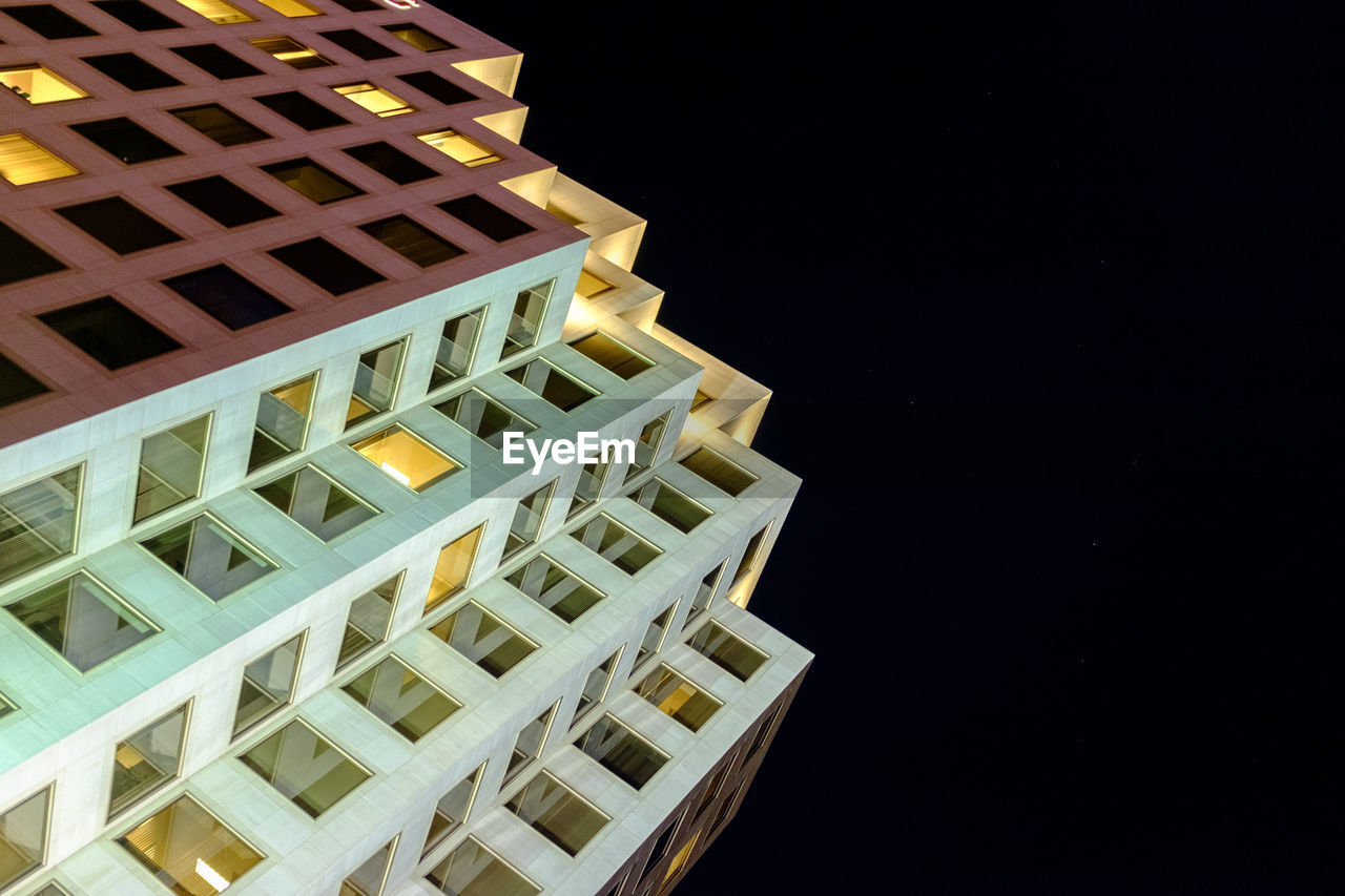 LOW ANGLE VIEW OF BUILDINGS IN CITY AT NIGHT