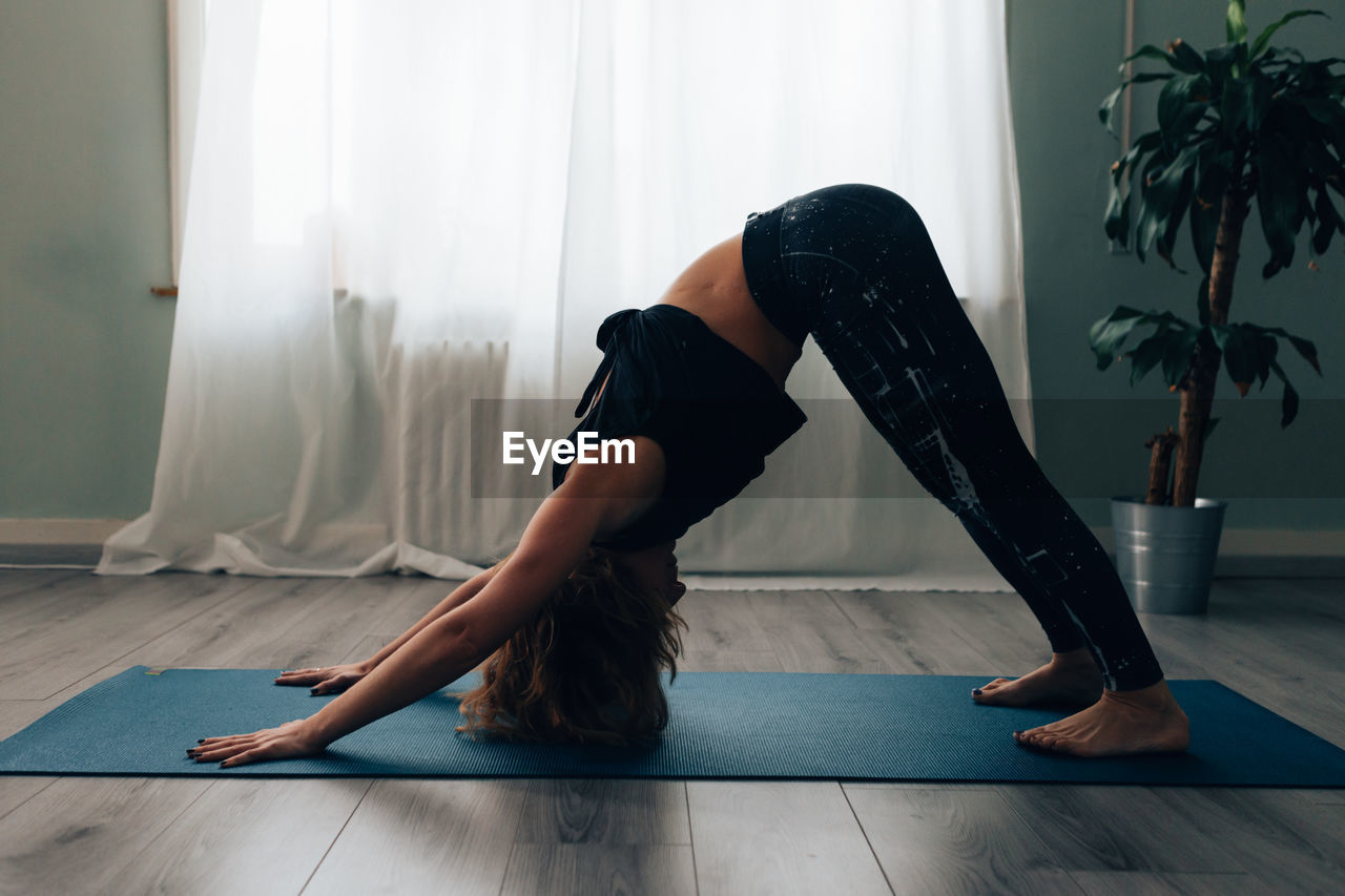 Yogic woman practicing in yoga studio