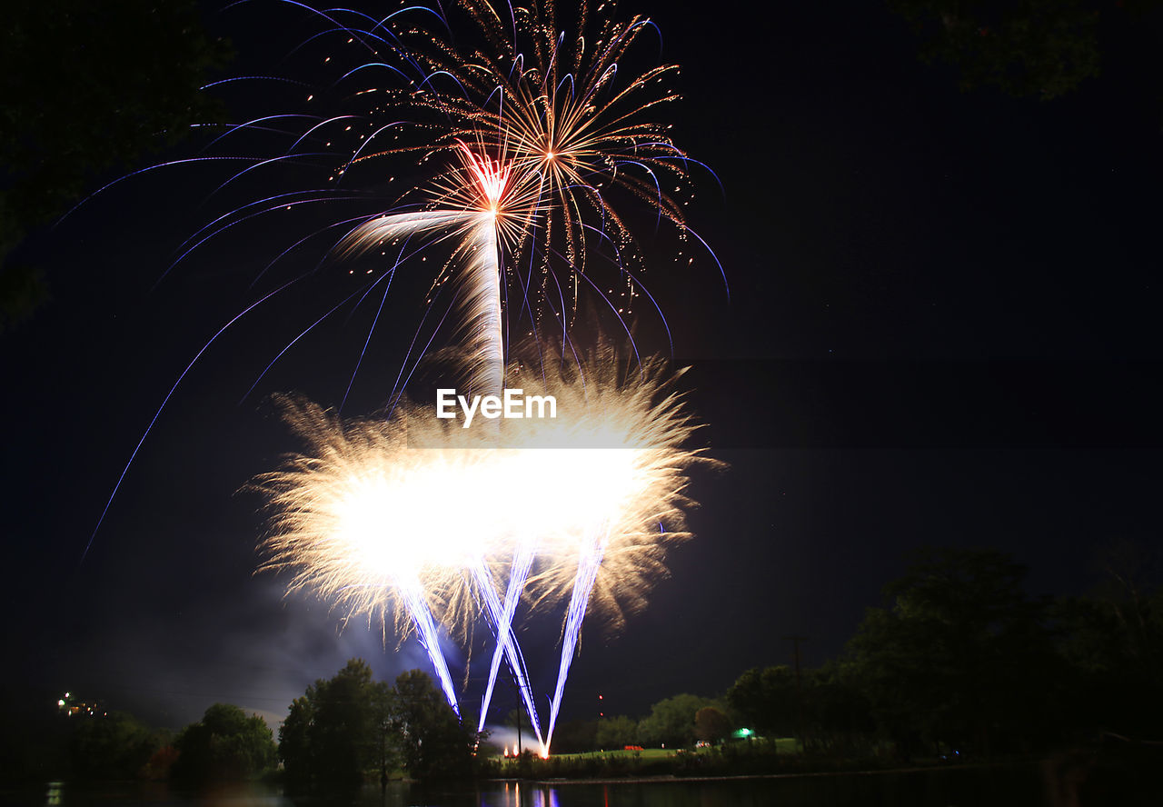 LOW ANGLE VIEW OF FIREWORKS DISPLAY AT NIGHT