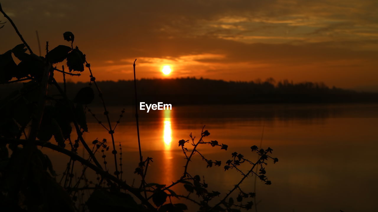 SCENIC VIEW OF LAKE AGAINST SKY AT SUNSET