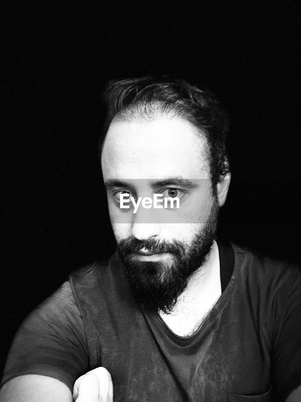 PORTRAIT OF YOUNG MAN OVER BLACK BACKGROUND