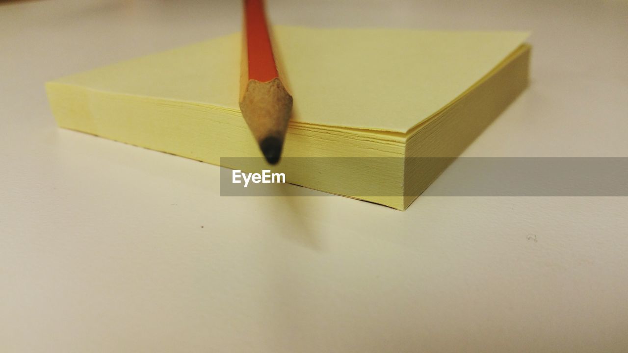 Close-up of adhesive notes and pencil on table