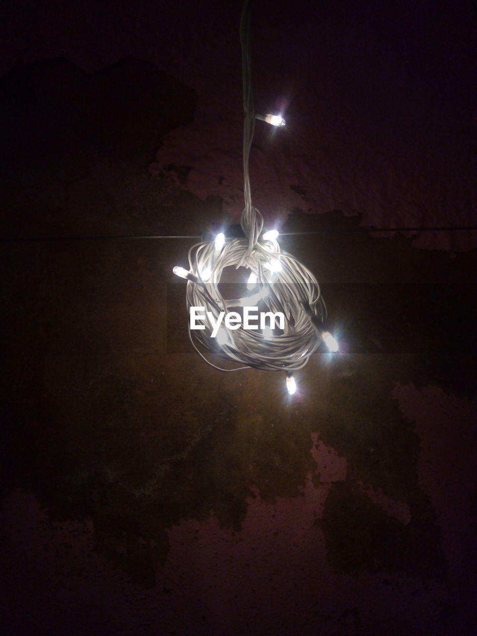 Close-up of illuminated string lights hanging in darkroom