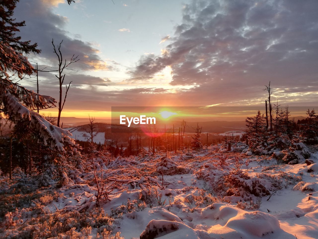 SCENIC VIEW OF SNOW COVERED LAND DURING SUNSET