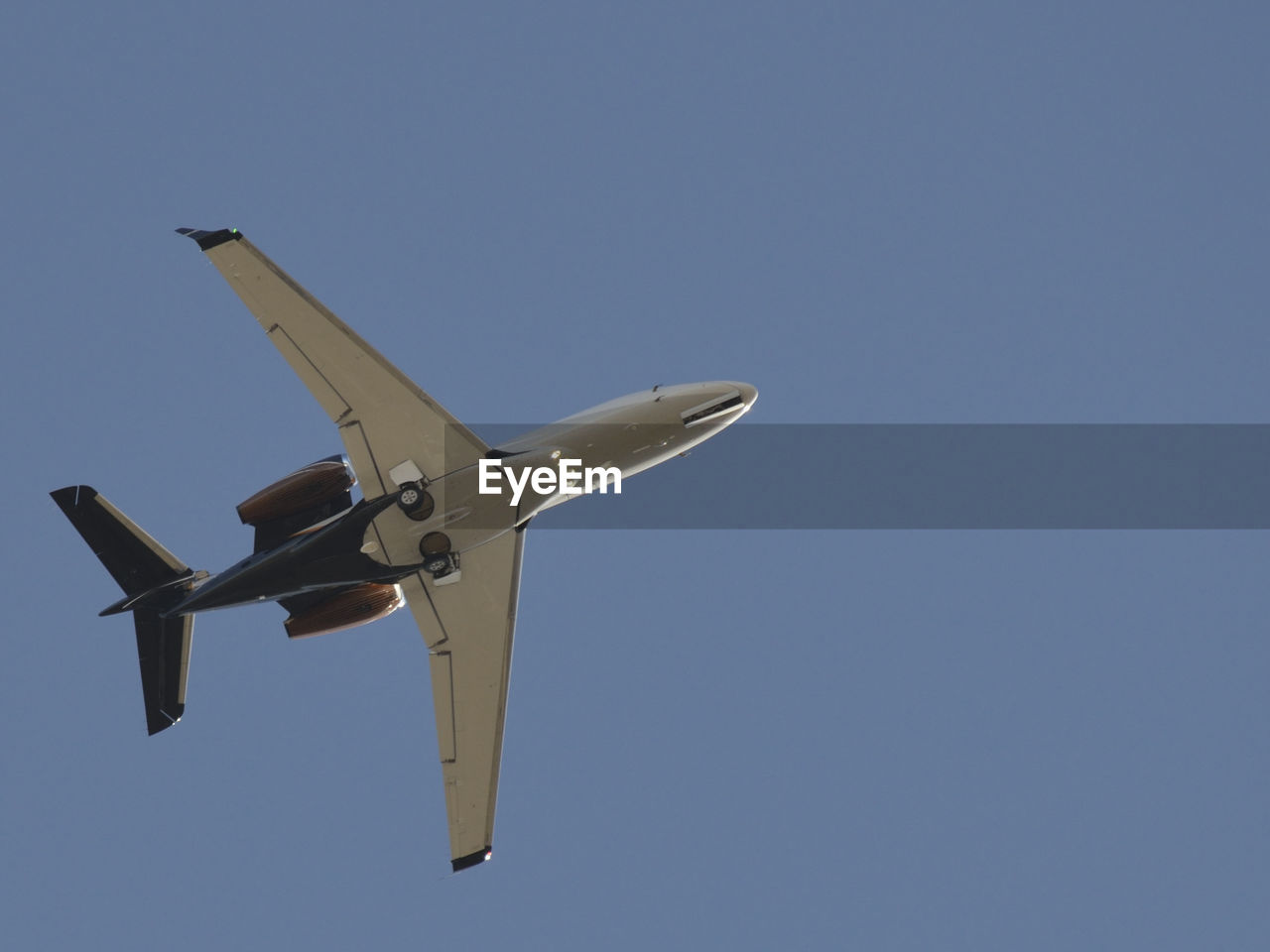 Low angle view of airplane flying in blue sky