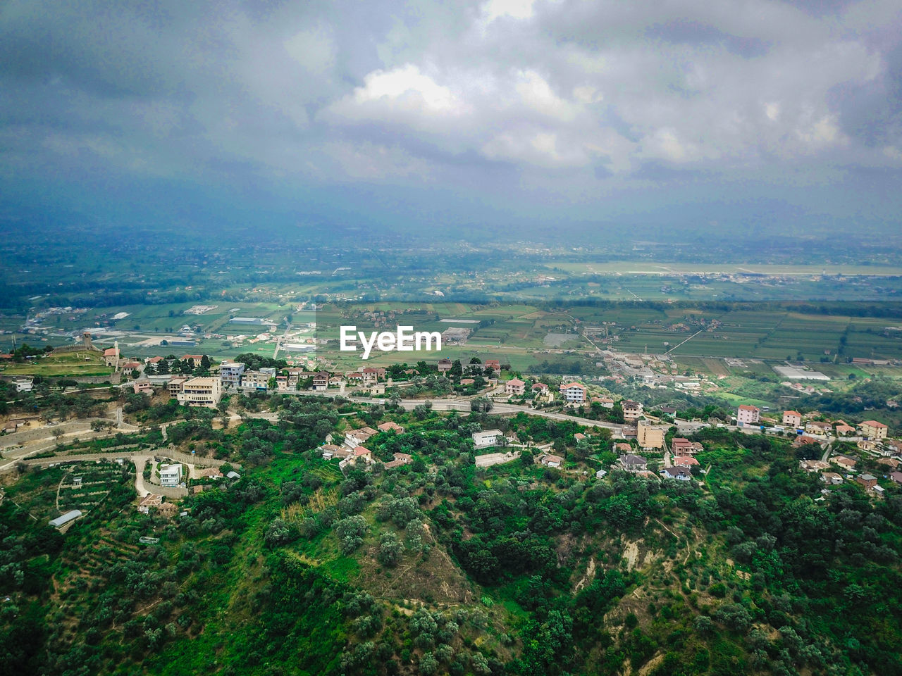 HIGH ANGLE VIEW OF TOWNSCAPE AND TREES AGAINST SKY