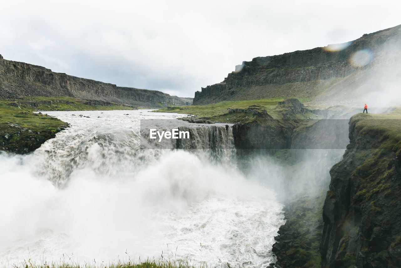 Scenic view of waterfall against sky