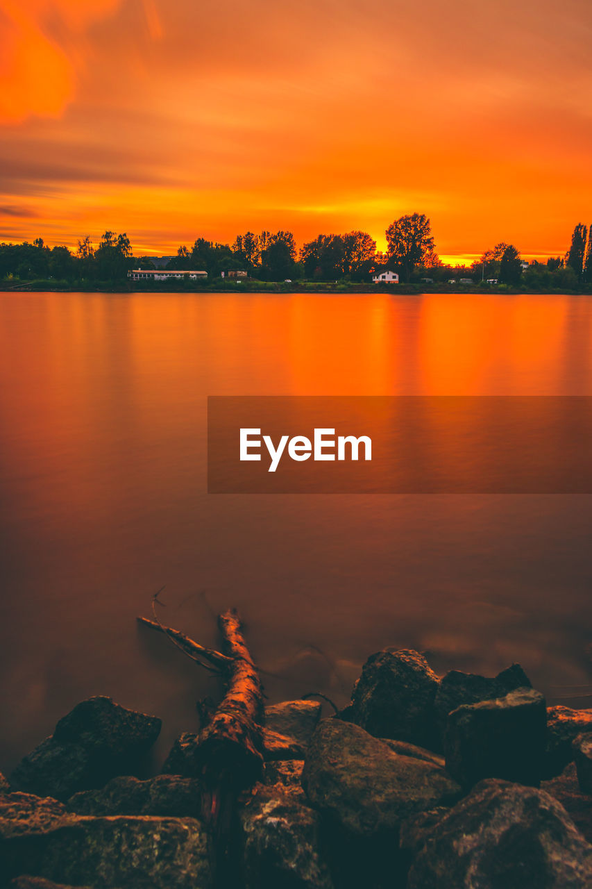 Scenic view of lake against orange sky