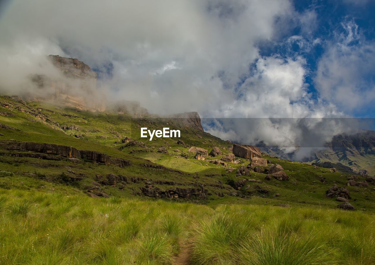 PANORAMIC SHOT OF LAND AND MOUNTAINS AGAINST SKY