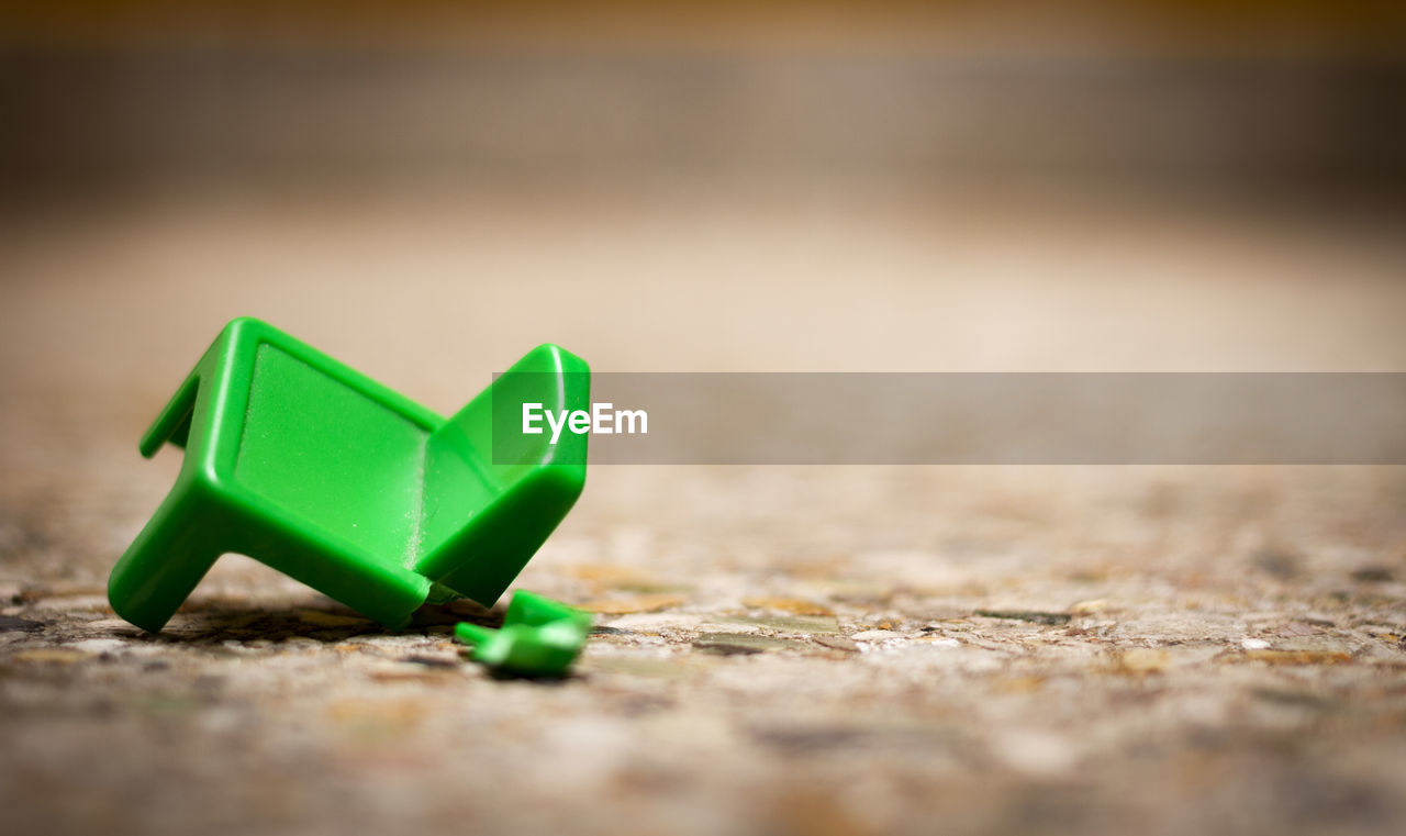 Close-up of broken green toy on table