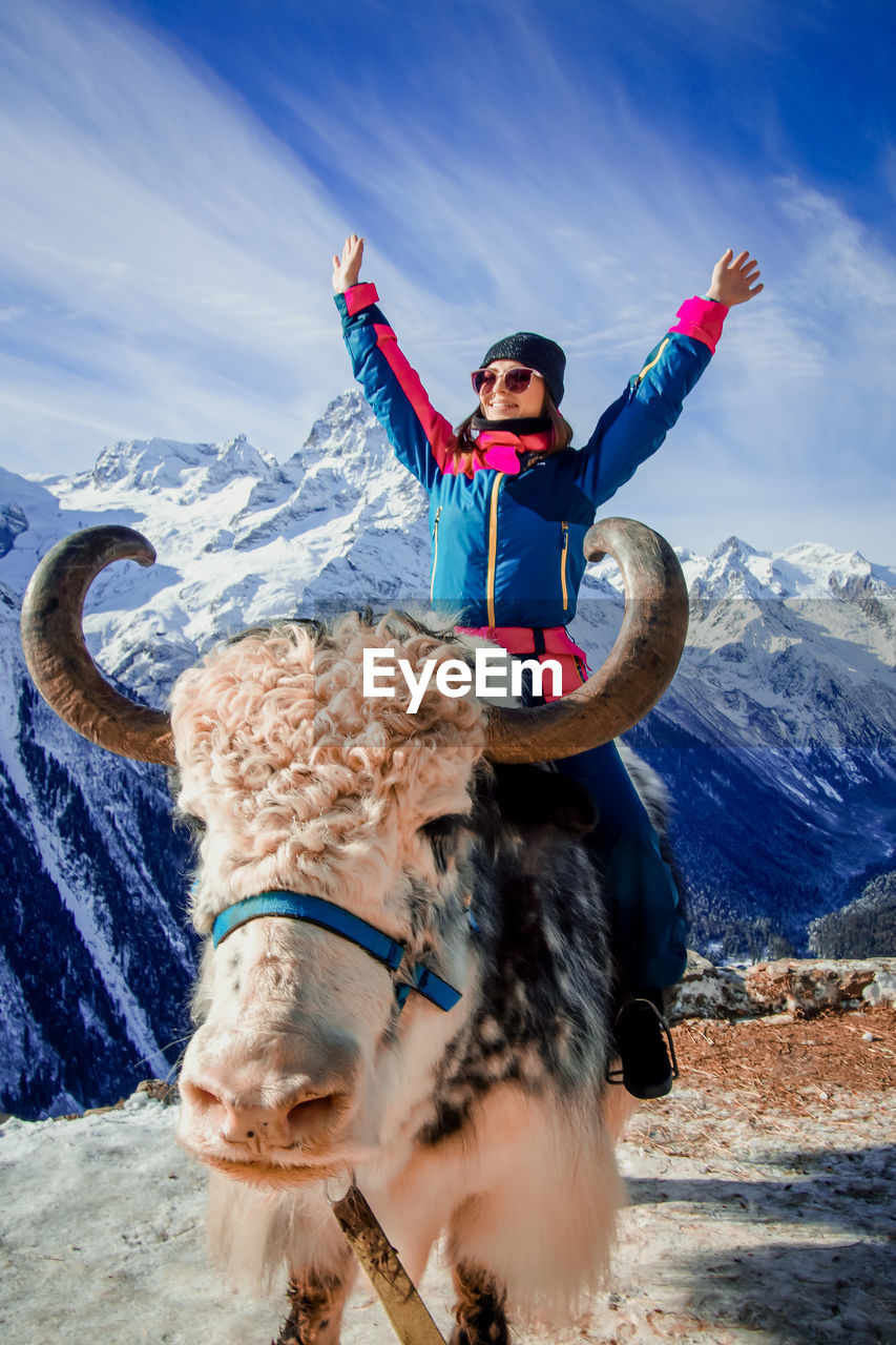 Boy on snow covered mountain against sky