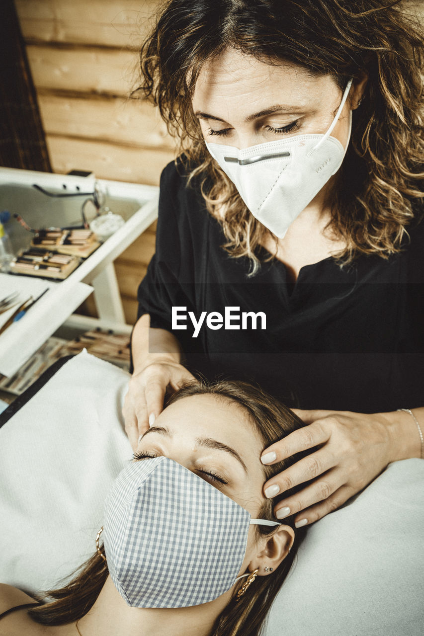 Beautician working with mask and protective screen for the virus covid