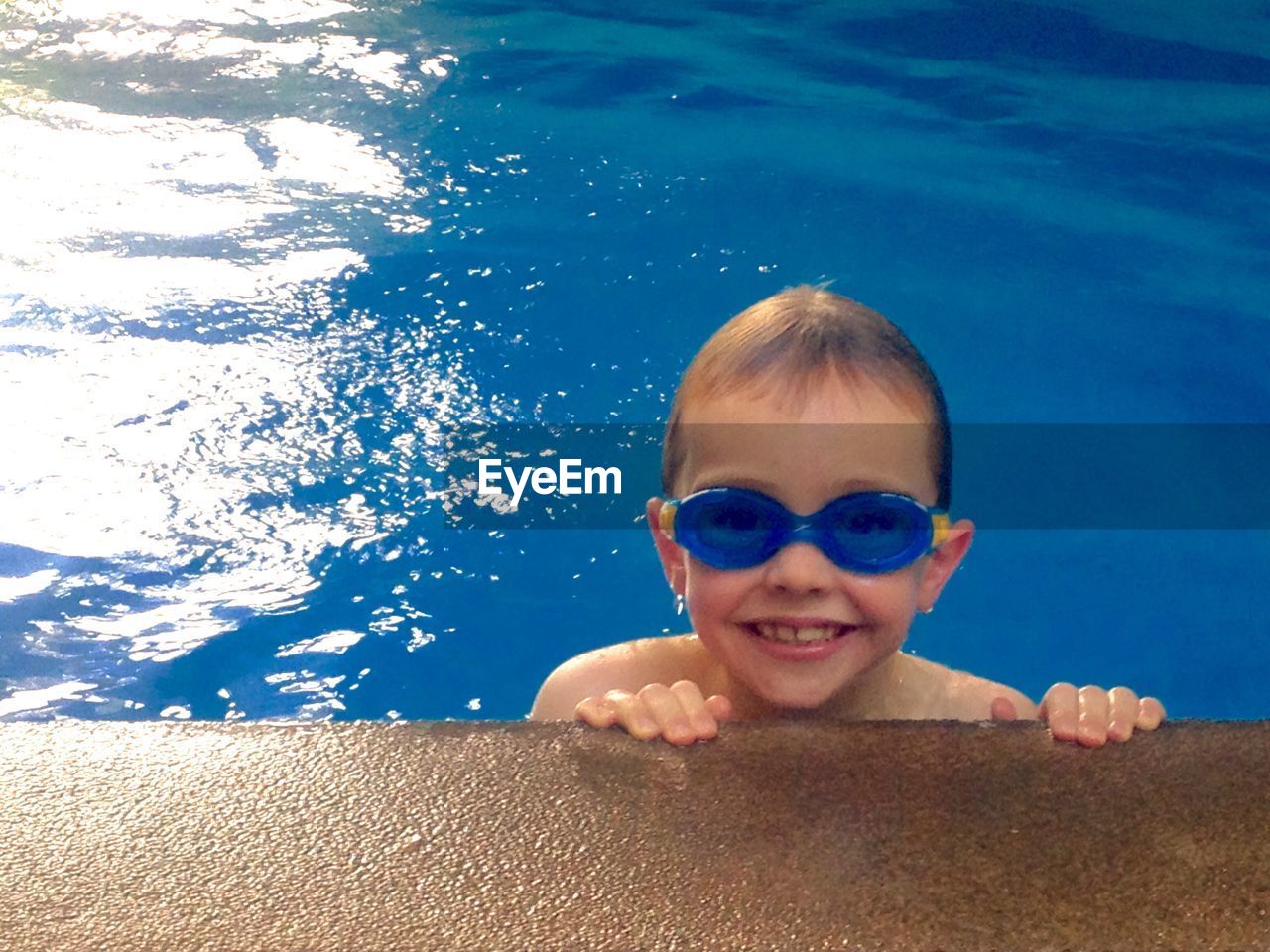 High angle portrait view of happy boy in swimming pool