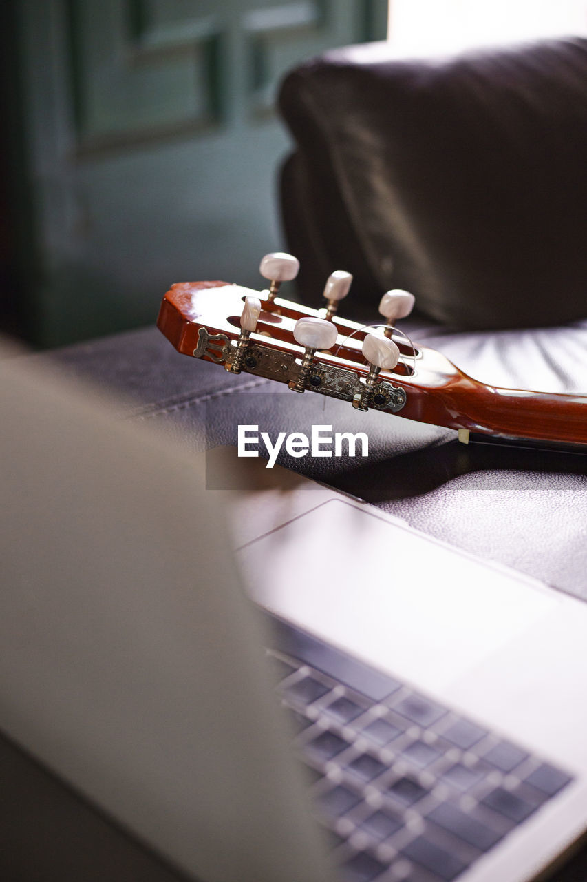 A laptop on the sofa to learn to play the guitar online