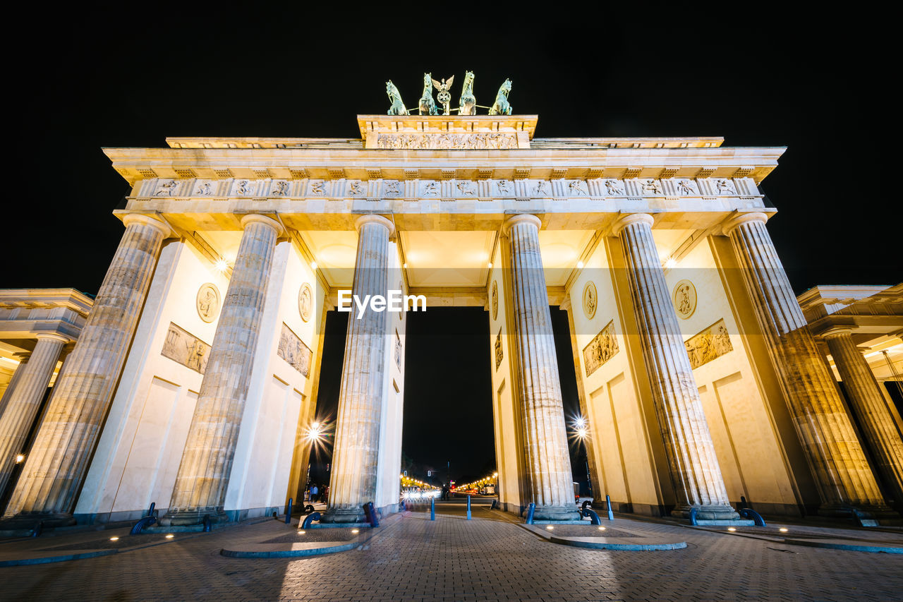 LOW ANGLE VIEW OF ILLUMINATED HISTORIC BUILDING AT NIGHT