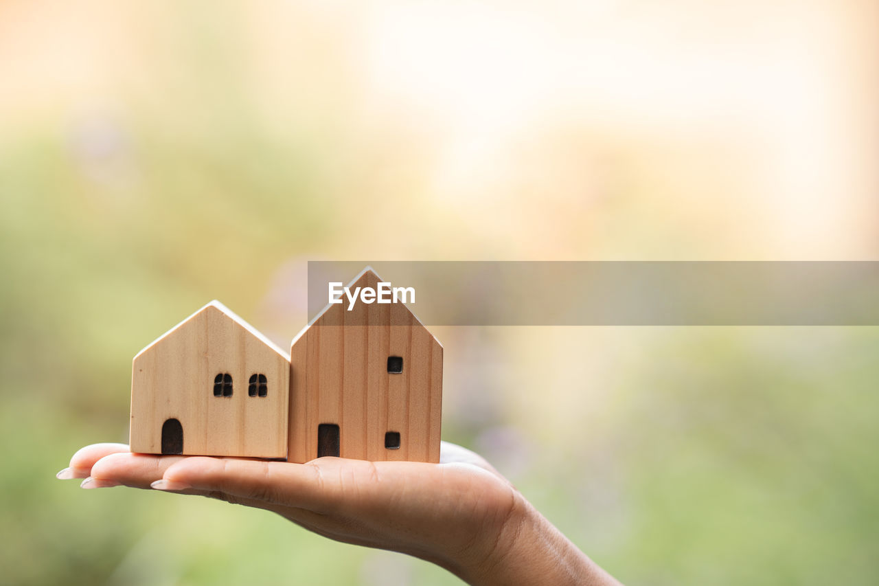 hand, close-up, one person, holding, focus on foreground, macro photography, toy, home ownership, childhood, copy space, child, house, architecture, wood, adult, creativity, outdoors, built structure, building, nature, residential district, building exterior
