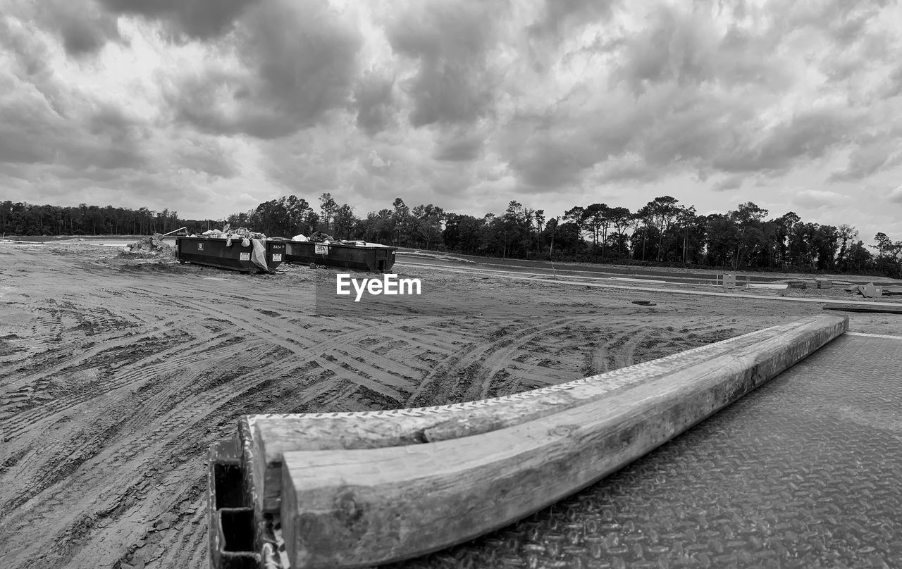 black and white, cloud, sky, monochrome, monochrome photography, nature, vehicle, land, landscape, transportation, environment, no people, day, water, rural scene, mode of transportation, outdoors, scenics - nature, agriculture, plant, nautical vessel, beach, boat, tree, sea