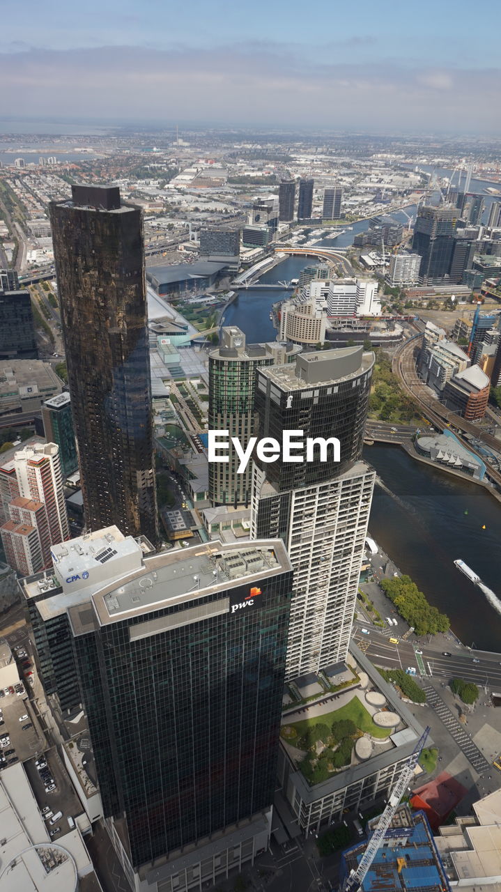 HIGH ANGLE VIEW OF MODERN CITYSCAPE AGAINST SKY