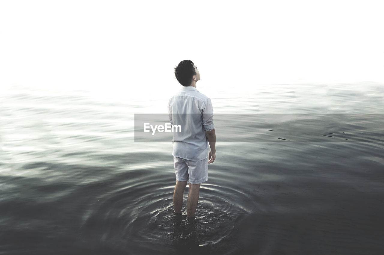 Rear view of man standing in water