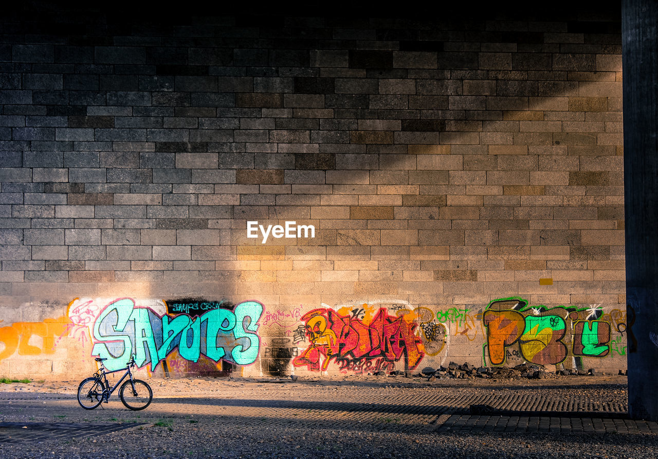 Parked bicycle against graffiti wall