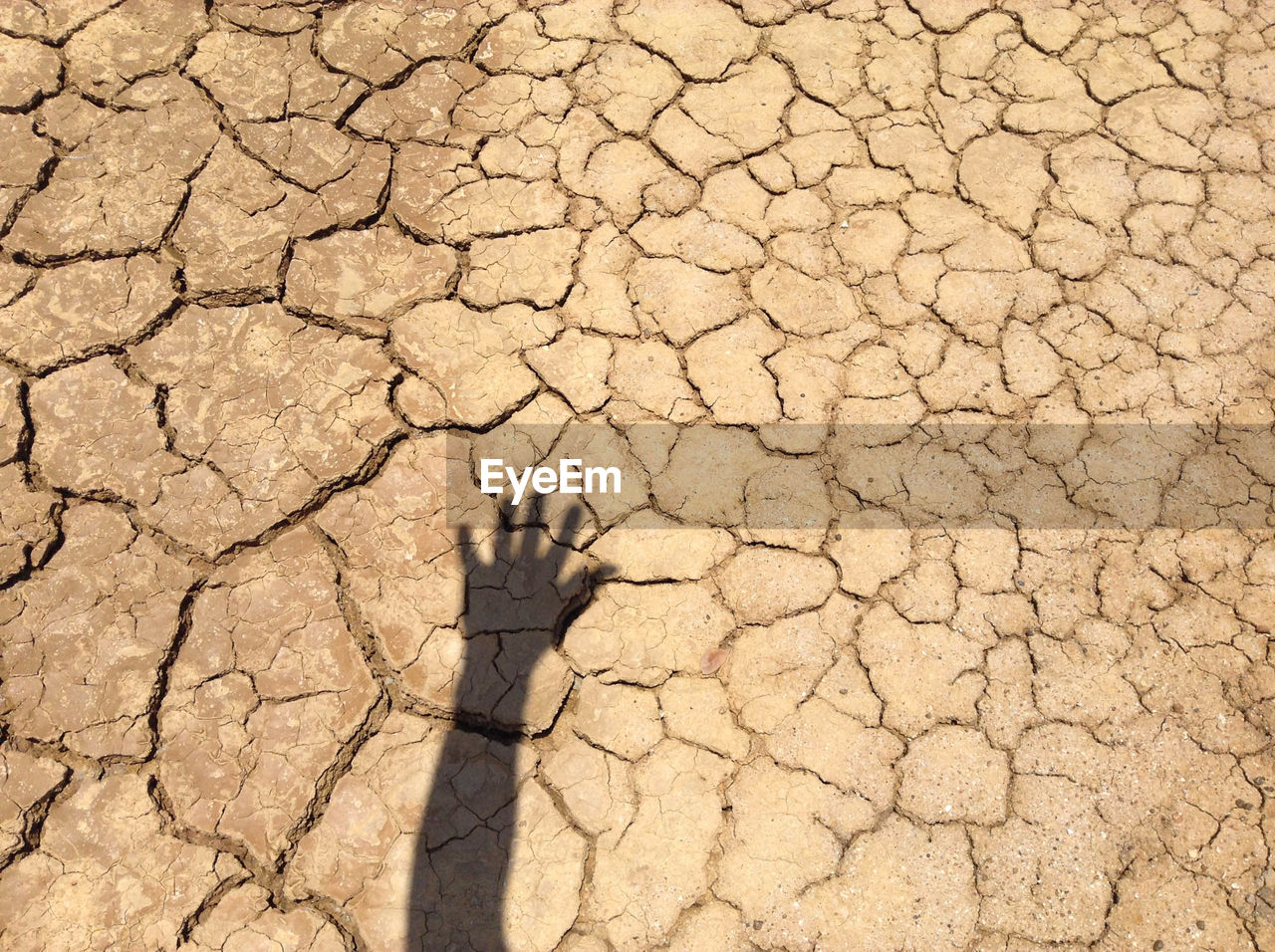 HIGH ANGLE VIEW OF CRACKED LAND ON COBBLESTONE