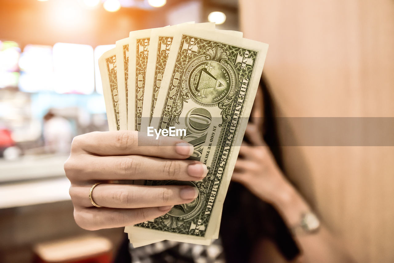 Close-up of woman holding dollar bills