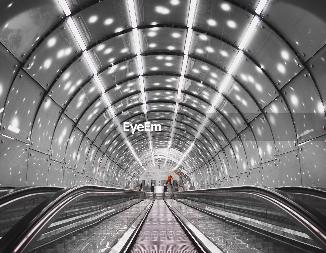 View of escalator in illuminated tunnel