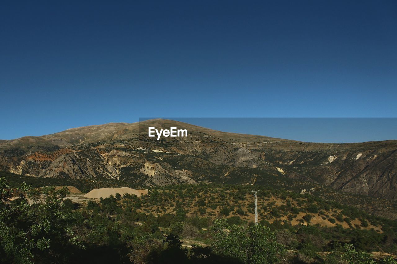 Scenic view of mountains against clear blue sky