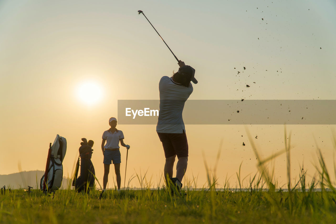 Couple lover in action of playing golf together. 