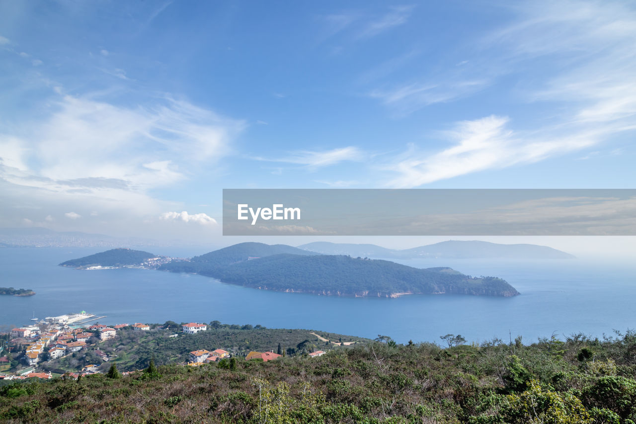 Scenic view of townscape by sea against sky