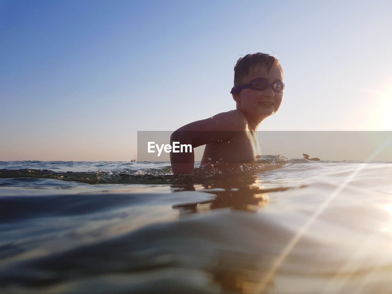 Portrait of smiling boy in sea against sky