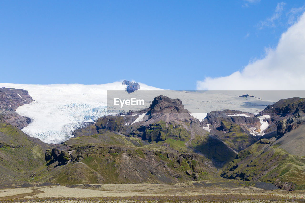 mountain, environment, landscape, scenics - nature, sky, snow, beauty in nature, mountain range, cold temperature, nature, winter, mountain pass, travel destinations, travel, land, snowcapped mountain, cloud, blue, plateau, tourism, no people, tranquility, wilderness, tranquil scene, day, adventure, outdoors, water, ridge, ice, highland, valley, glacier, sunny, non-urban scene, mountain peak, lake, vacation, trip, social issues, rock, holiday, activity, clear sky, idyllic