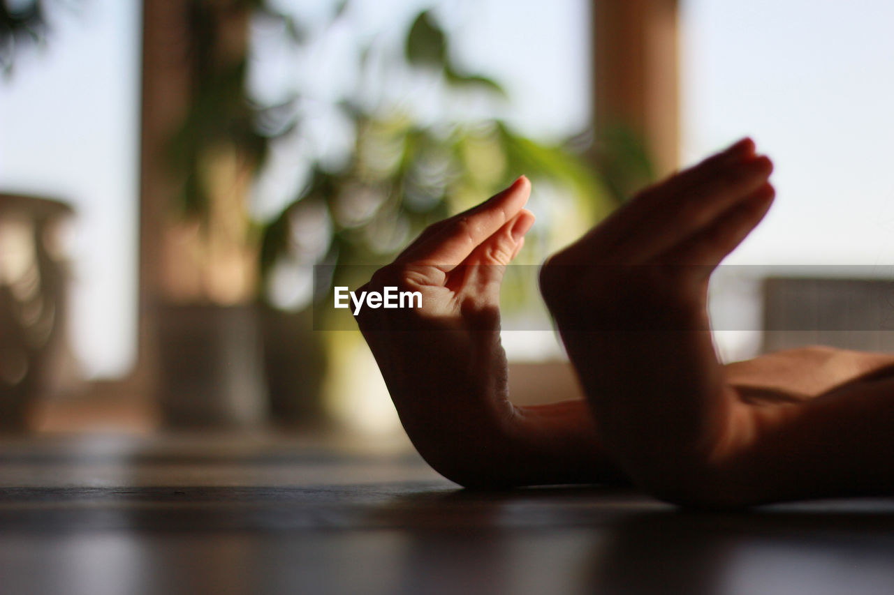 Close-up of cropped hands gesturing on floor