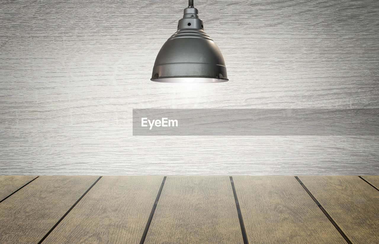 CLOSE-UP OF ELECTRIC LAMP HANGING ON WALL