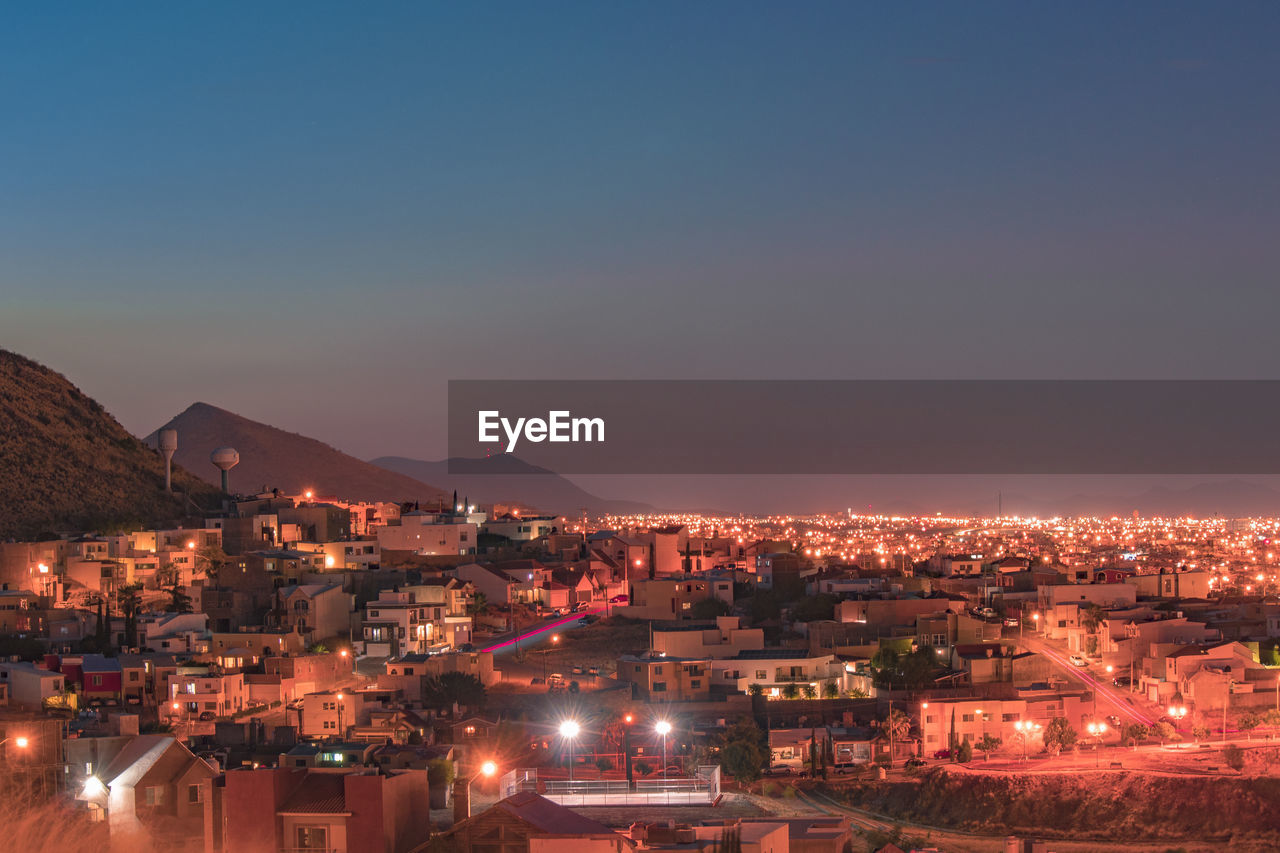 High angle view of illuminated buildings in city at night