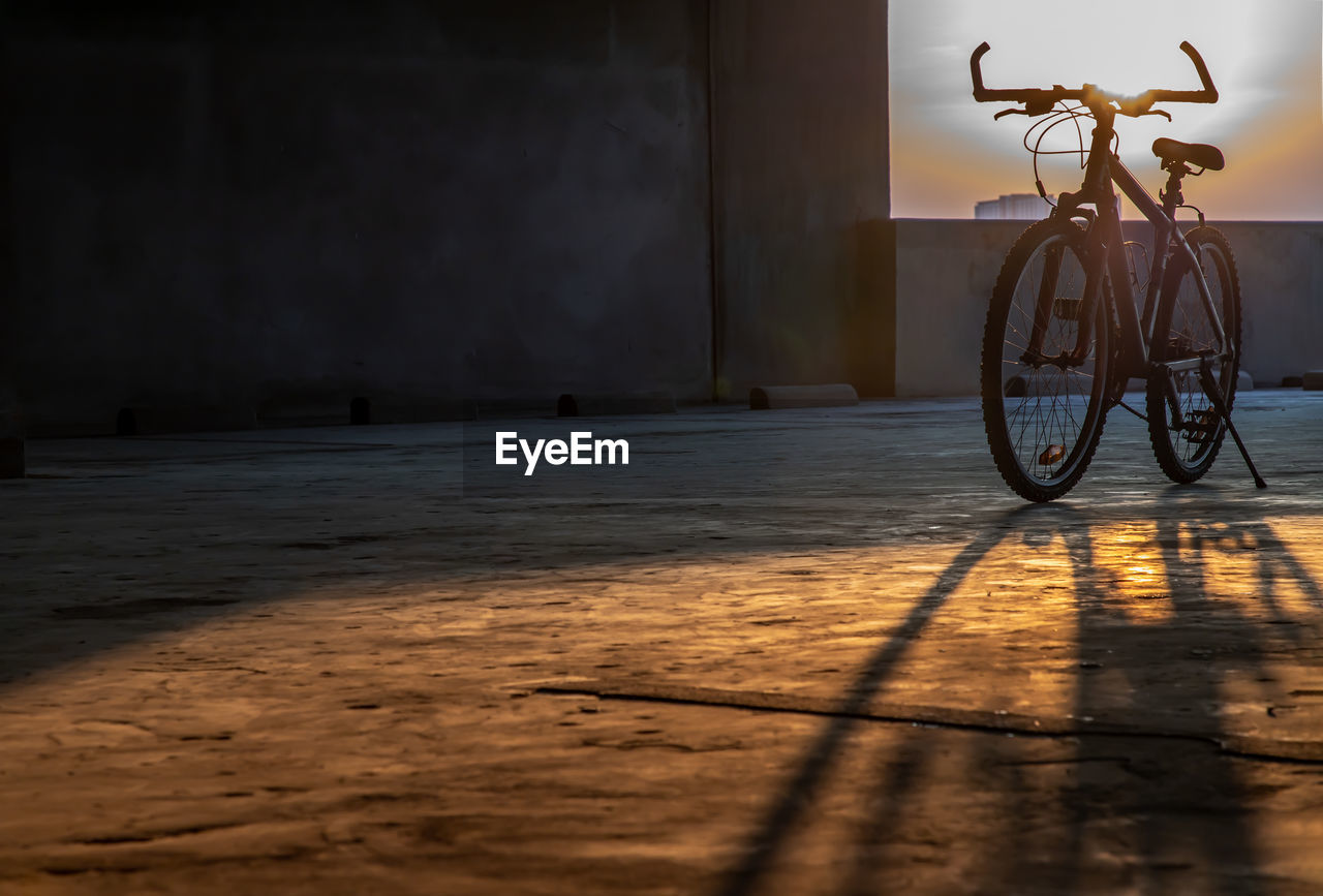 BICYCLE PARKED ON FOOTPATH BY WALL