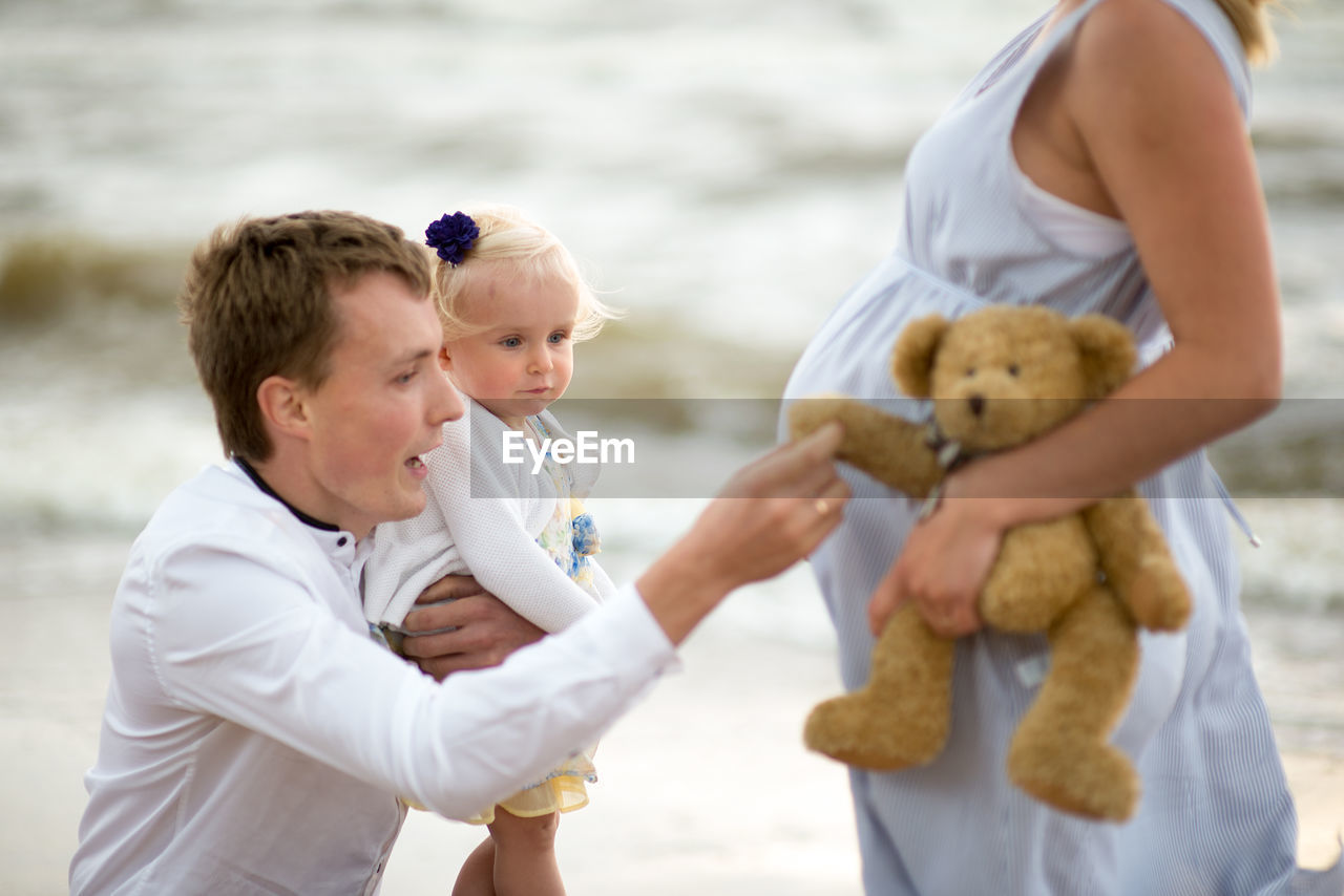 Man with daughter and woman at beach