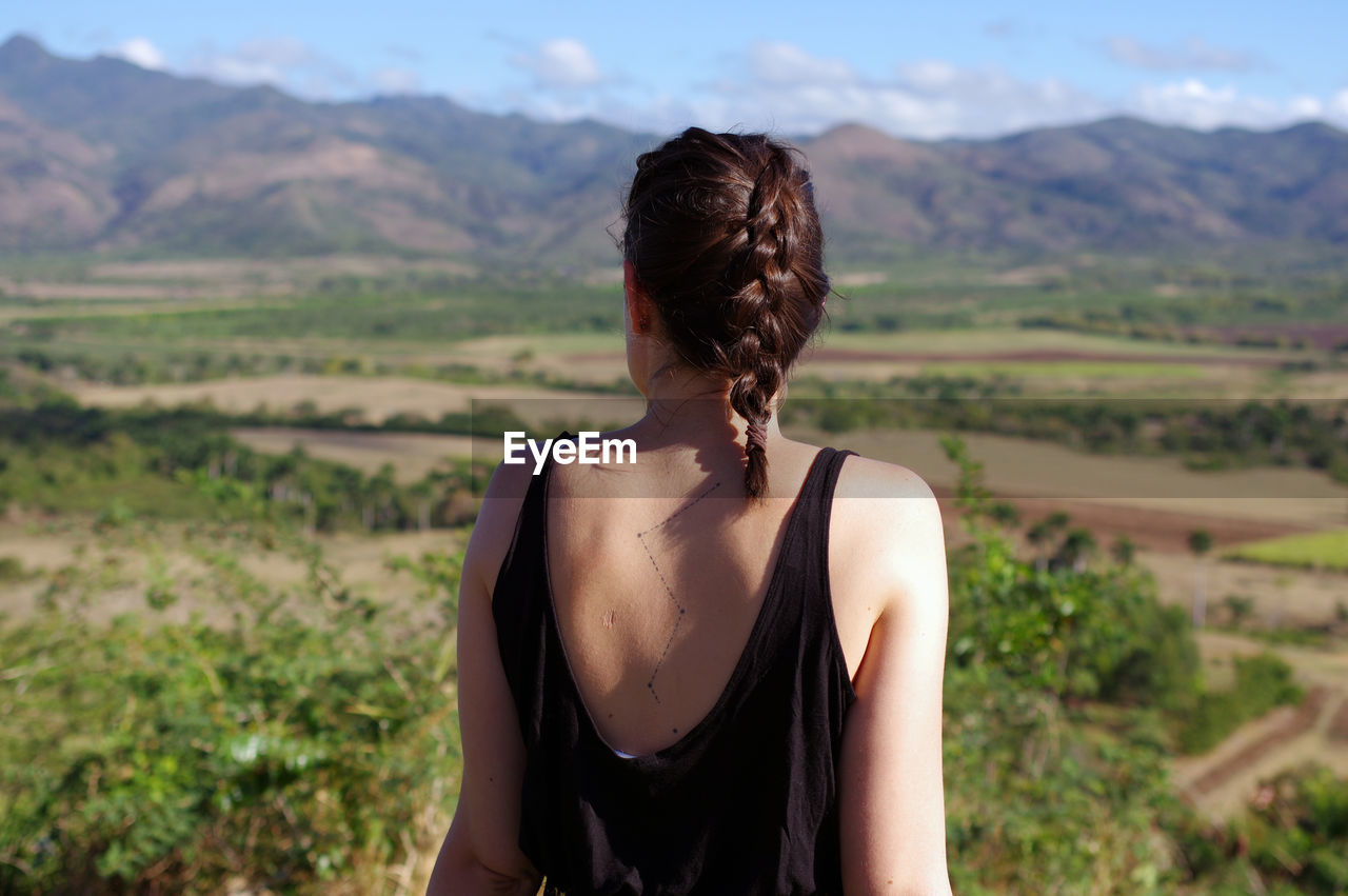 Rear view of woman standing looking at mountains