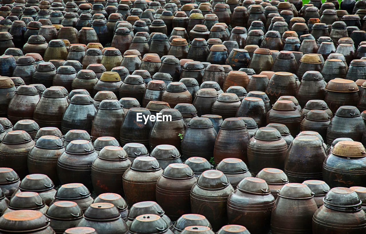 Full frame shot of metallic barrels arranged on field