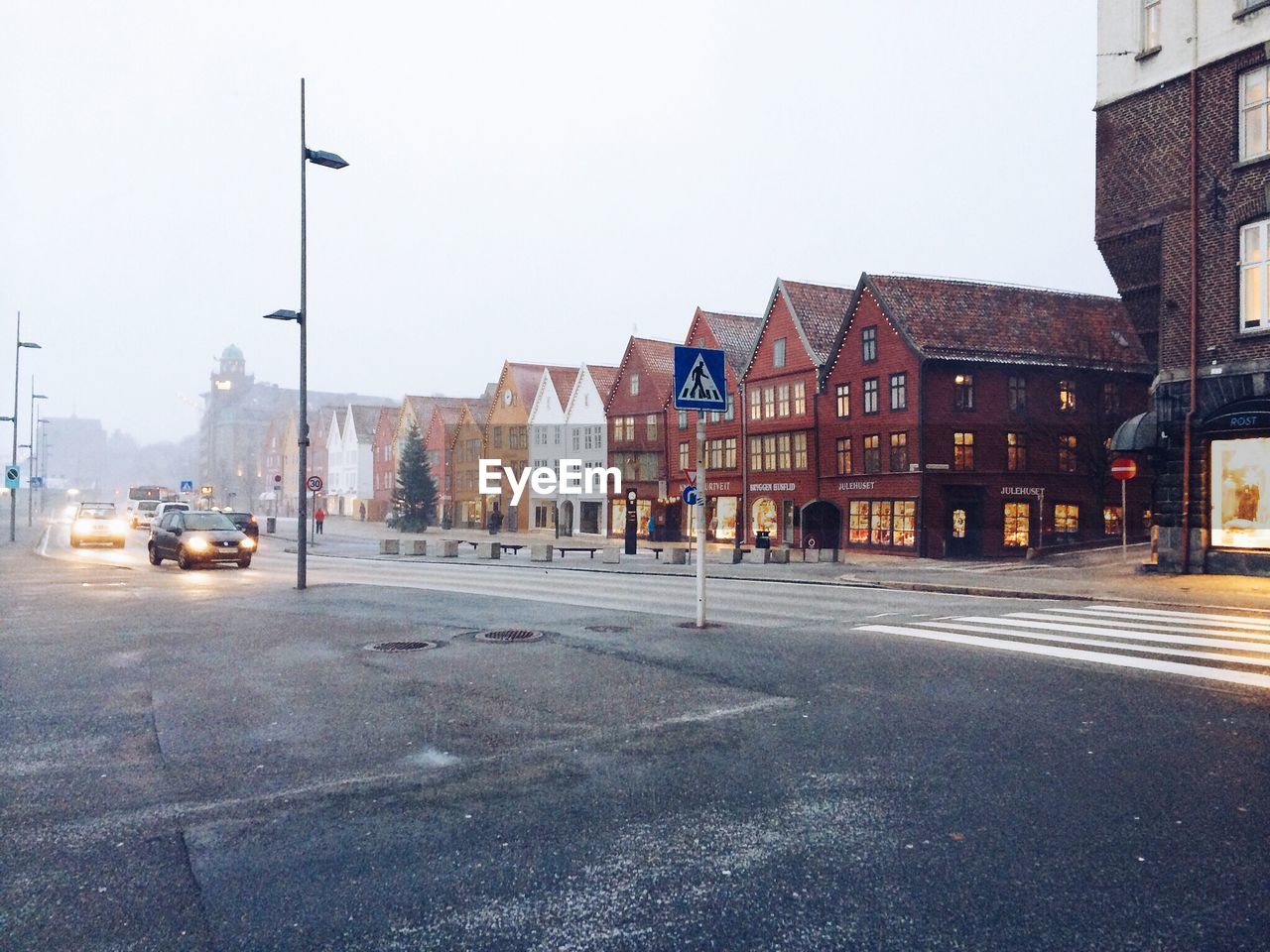 Cars on street by houses against clear sky