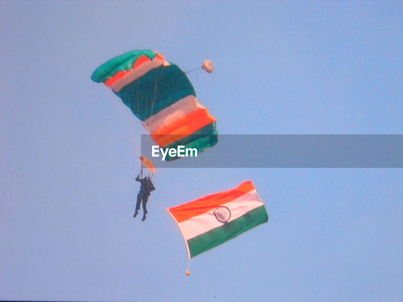 LOW ANGLE VIEW OF KITE FLYING AGAINST BLUE SKY