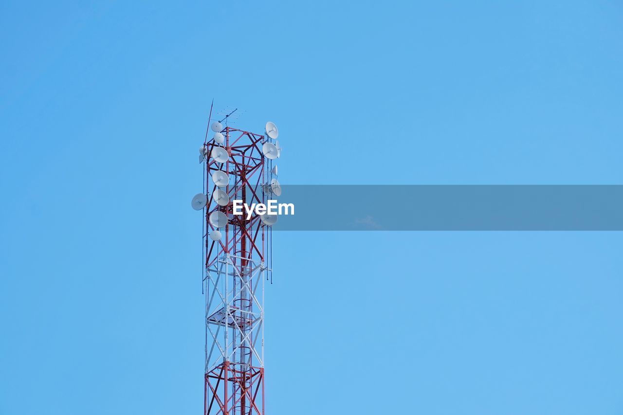 Low angle view of communications tower against blue sky