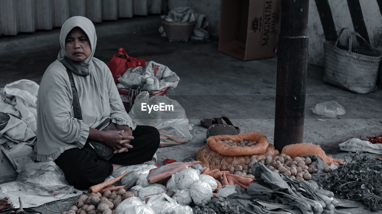 Full length of woman selling vegetables at market stall