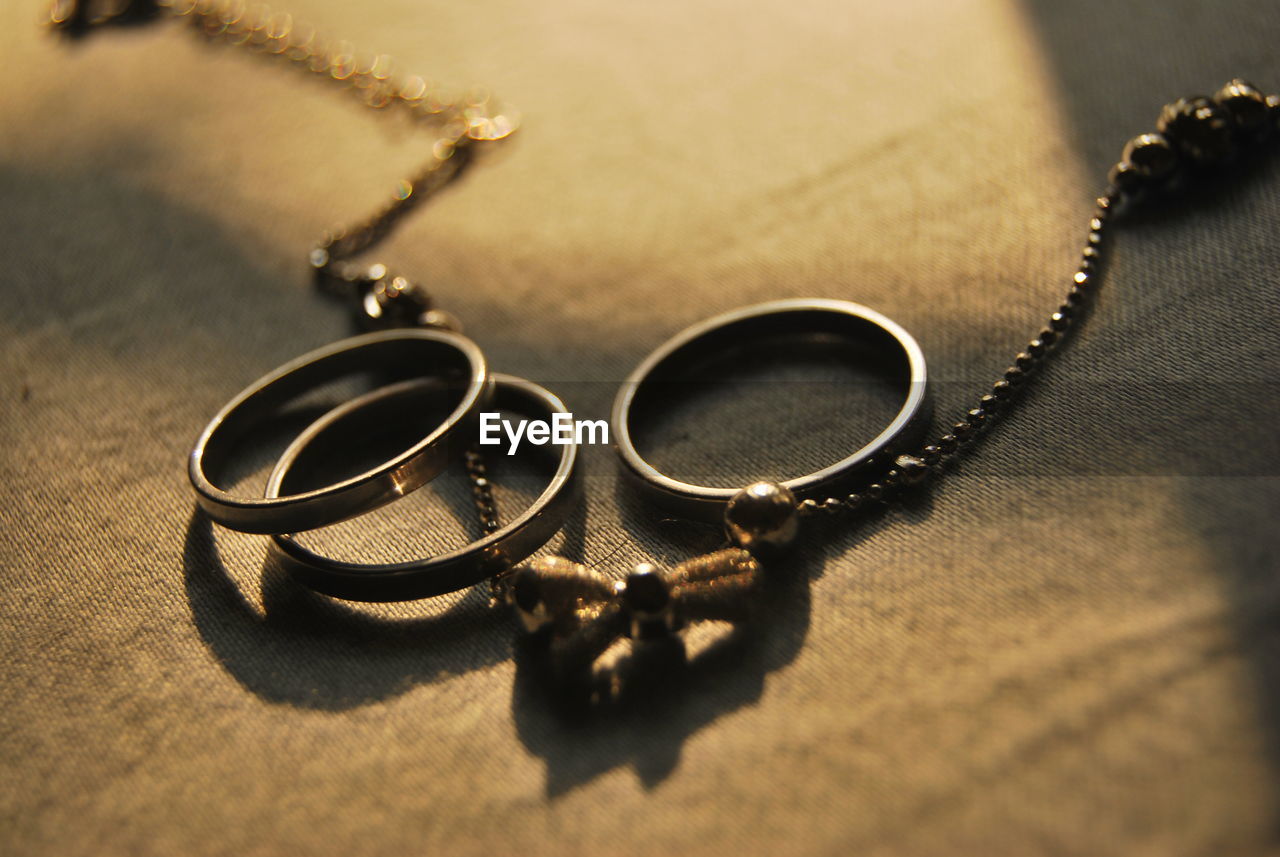 High angle view of wedding rings and a bracelet