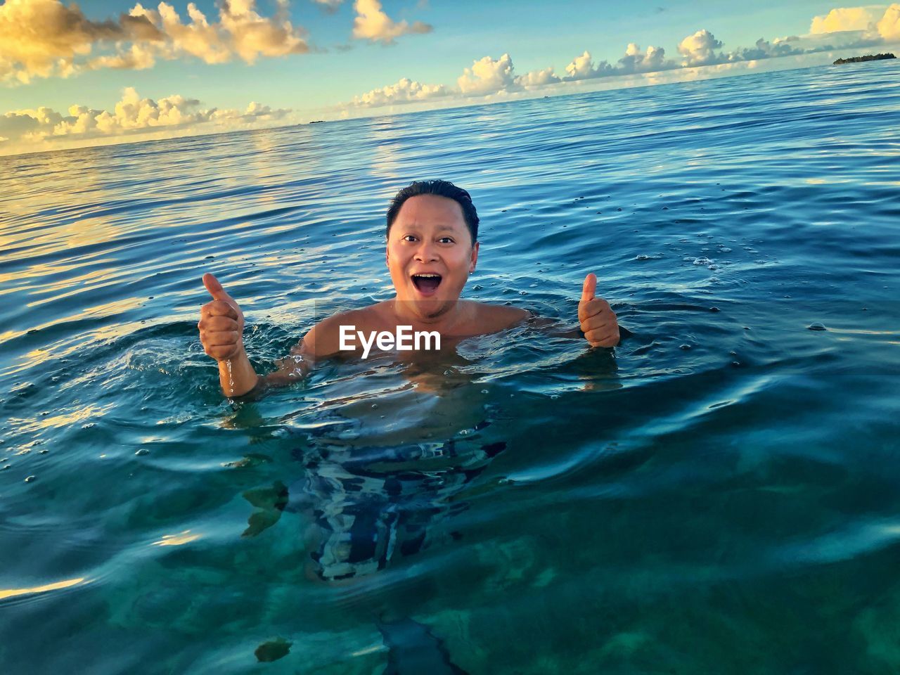 PORTRAIT OF MATURE MAN SWIMMING IN SEA