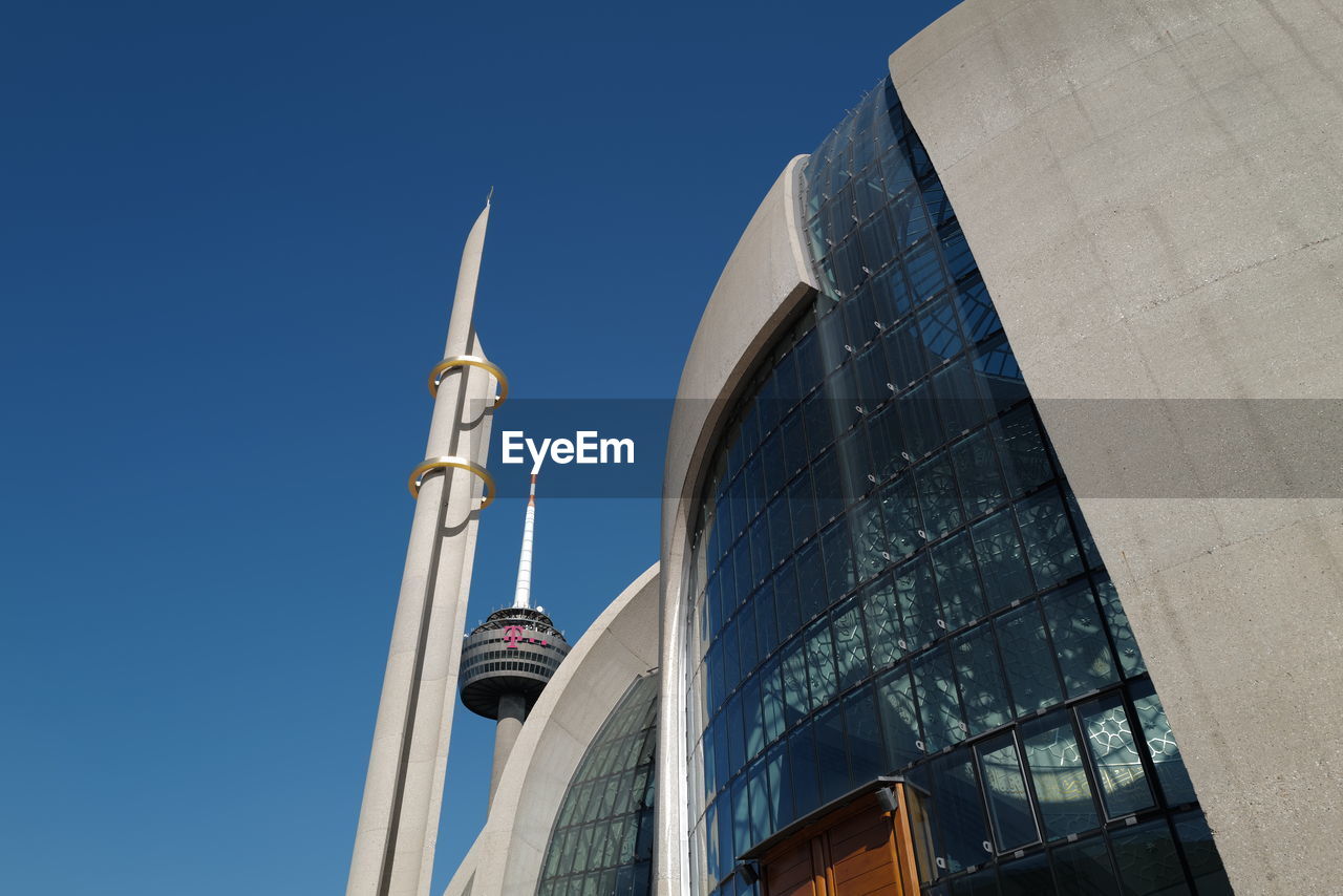 LOW ANGLE VIEW OF MODERN BUILDING AGAINST CLEAR BLUE SKY